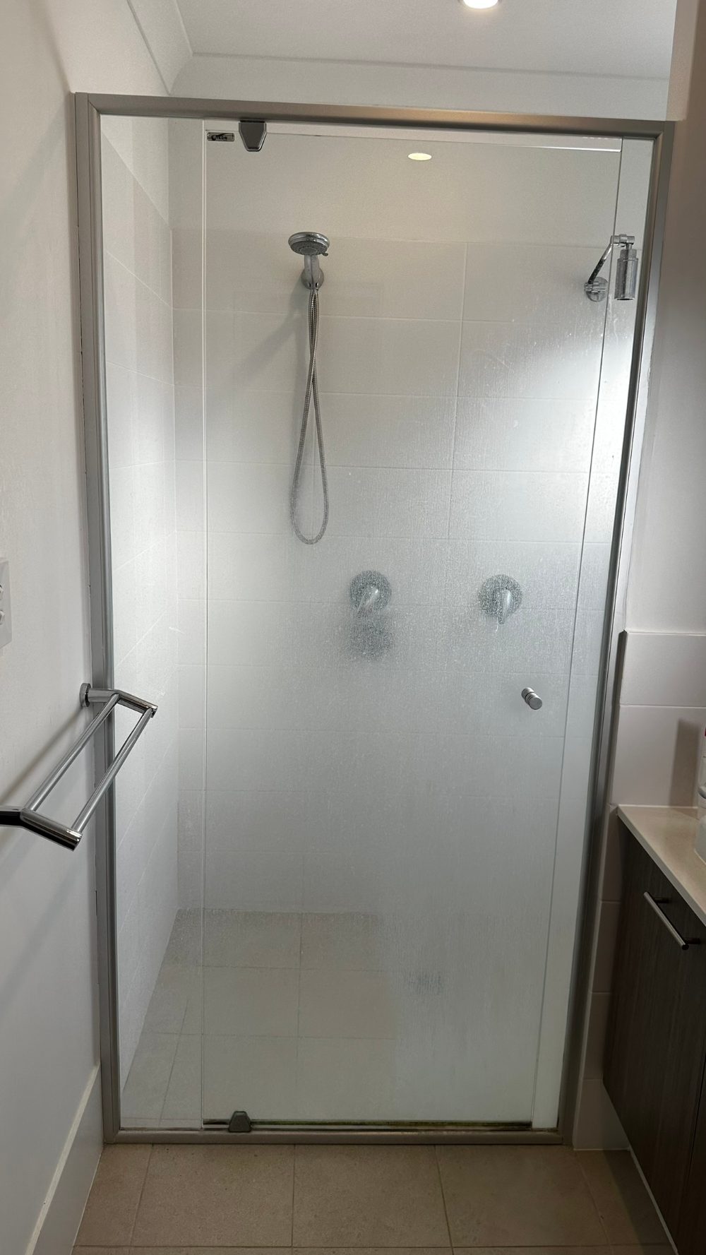 Shower screen glass caked with hard-water scale before treatment